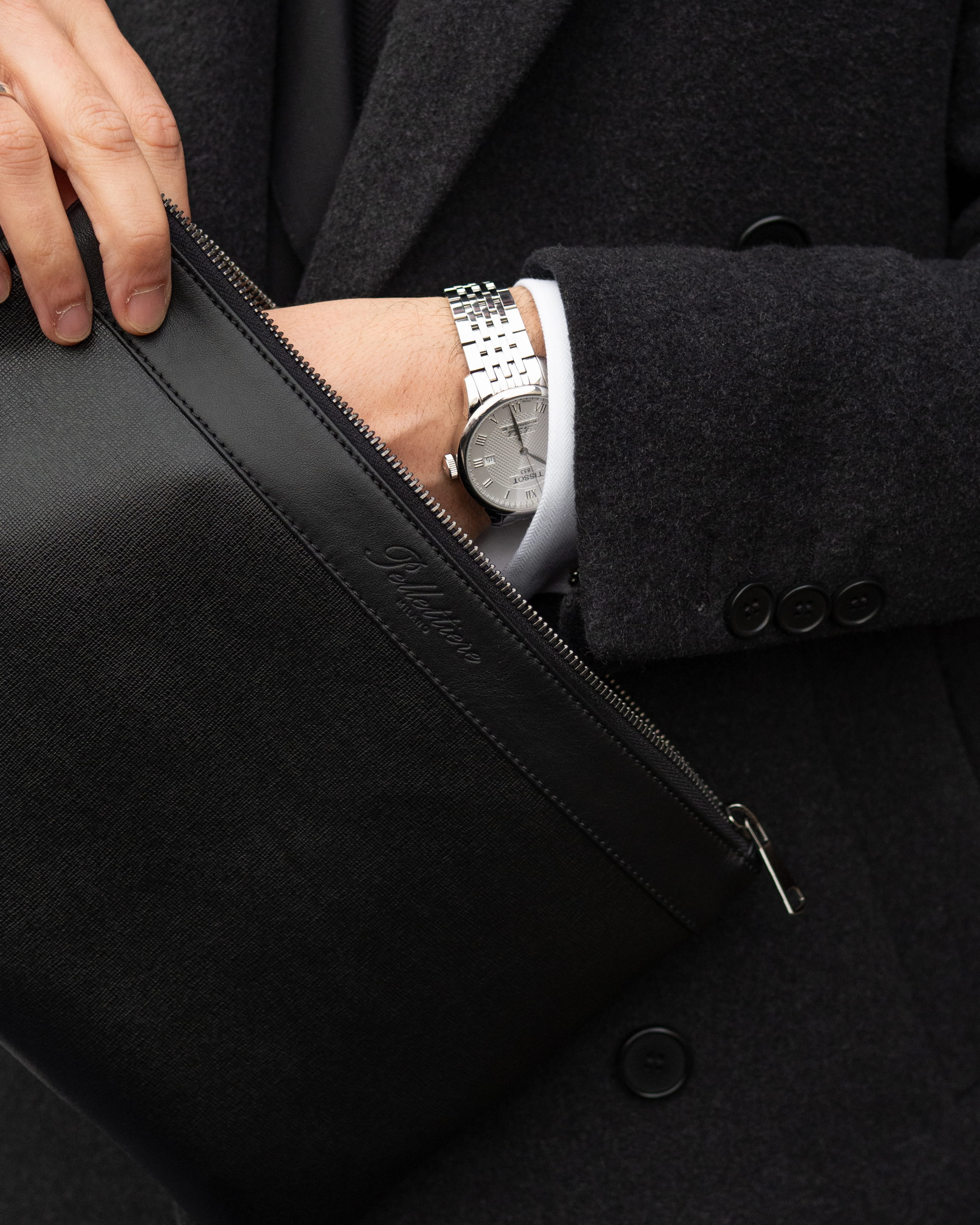 Business-Look mit Leder Tasche (Pouch), Mann im dunklen Mantel greift in flaches Herren Portmonee Accessoire, handgenäht.